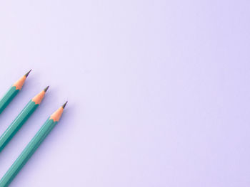 Close-up of colored pencils over white background