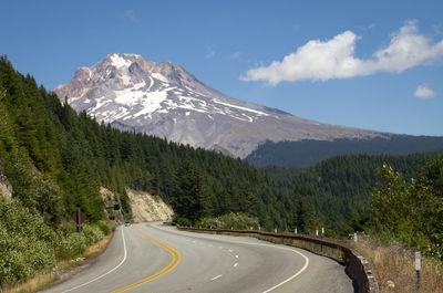 Scenic view of road by mountains against sky