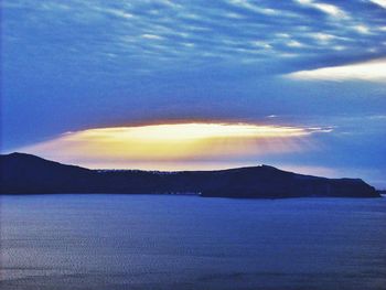 Scenic view of dramatic sky over mountains during sunset