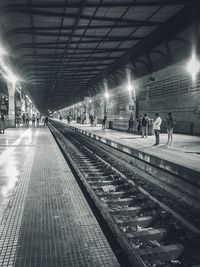 People waiting at railroad station at night