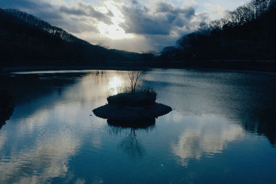 Scenic view of lake against sky at sunset