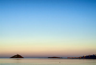 Scenic view of sea against clear sky during sunset