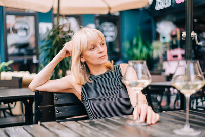 Mature woman looking away while sitting at cafe