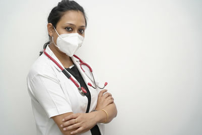 Portrait of teenage girl standing against white background