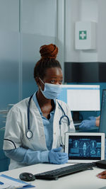 Doctor wearing mask showing medical tablet