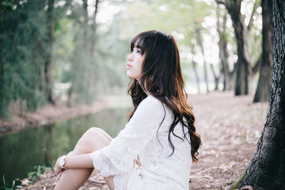 Side view of young woman in forest