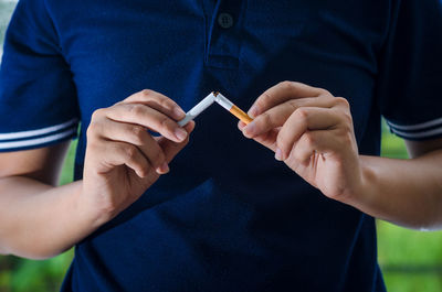 Midsection of man quitting smoking 