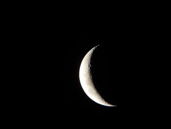 Low angle view of half moon against sky at night