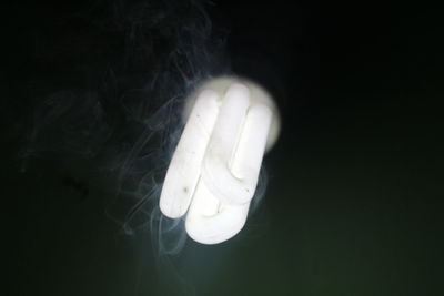 Close-up of woman hand against black background