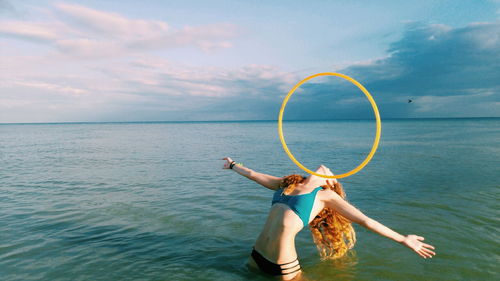 Full length of woman standing on sea against sky