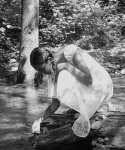 Girl sitting on tree trunk