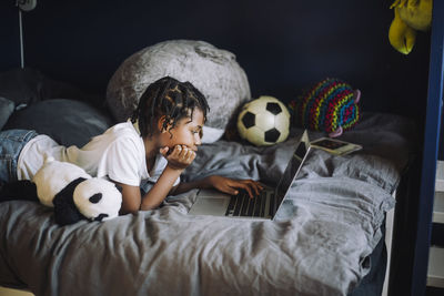 Ambitious girl learning coding on laptop in bedroom