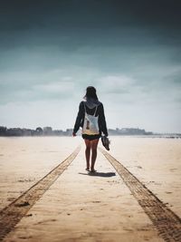 Rear view of man walking on beach