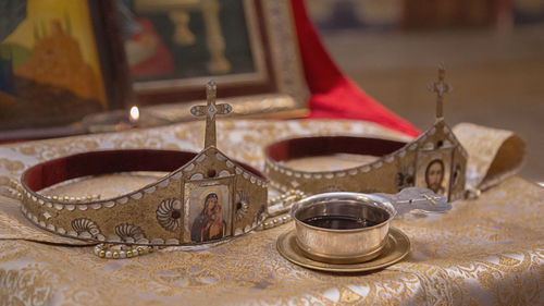 Close-up of wine in bowl by crowns on altar in church