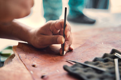 Midsection of man working on table