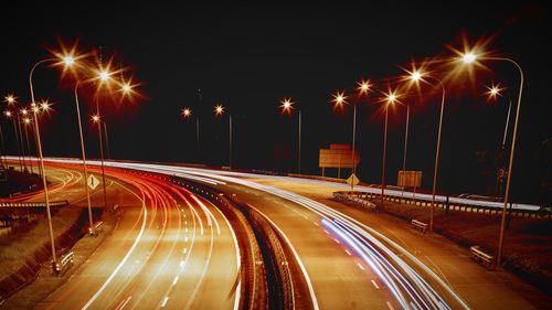 Light trails on illuminated road at night