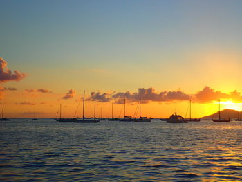 Boat sailing in sea at sunset