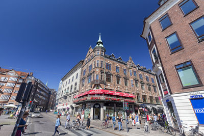 People on street against buildings in city