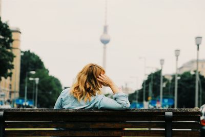 Woman looking at city against sky