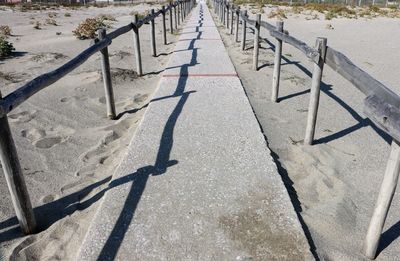 High angle view of footpath by railing in city