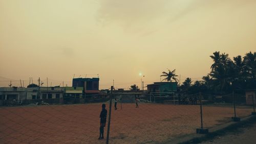 People on beach against sky during sunset