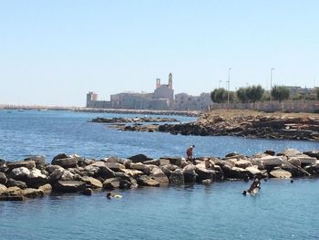 View of calm sea with buildings in background