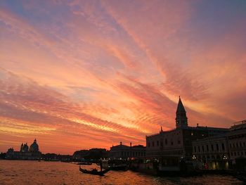 Buildings at waterfront during sunset