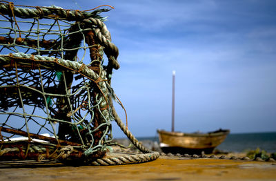 Close-up of lobster trap on pier against sky