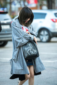 Woman with umbrella on street in city