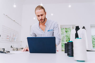 Fashion designer using laptop at studio