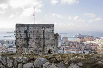 Buildings by sea against sky in city