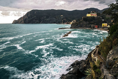 Monterosso al mare bay and village with cliff, trail and rough sea during, la spezia, liguria, italy