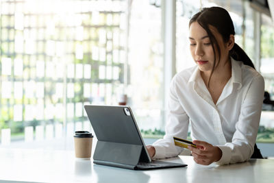 Woman looking at camera while sitting on table