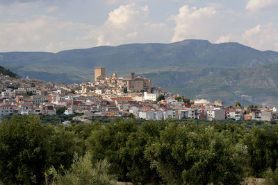 Town by mountains against sky