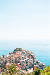 High angle view of sea and buildings against clear sky