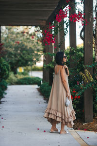 Rear view of woman standing against trees