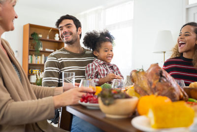 People sitting by food on table