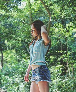 Low angle view of woman standing on tree