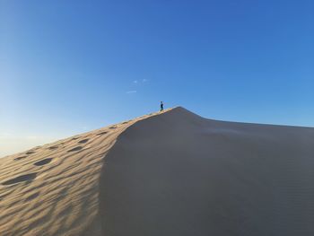 Scenic view of desert against clear blue sky