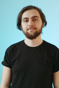 Portrait of young man against blue background