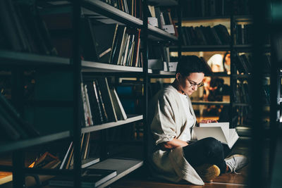 Rear view of man standing in library