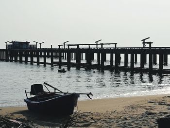 Silhouette boat on beach against clear sky