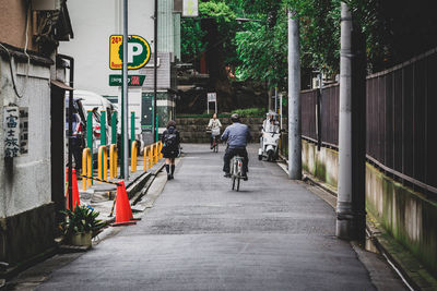 People cycling and walking on street in city