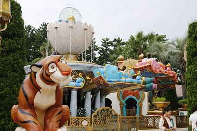 Statues in park against sky