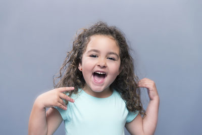 Portrait of smiling girl against gray background