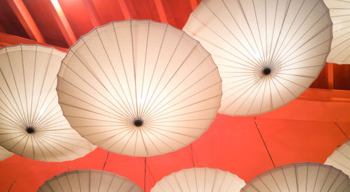 Low angle view of white umbrellas hanging from ceiling