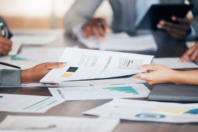 Midsection of business colleagues working on table