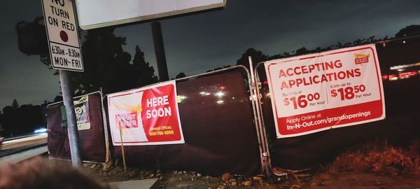 Information sign on road against sky at night