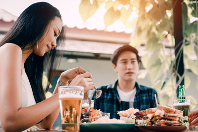 Midsection of woman sitting at restaurant table