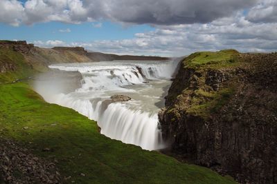 Scenic view of waterfall against sky